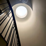 N Clark Window Cleaning cleaning second-floor windows by hand on a ladder in Putney — perfect clear finish